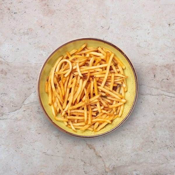 A vibrant yellow bowl filled with crispy, golden french fries, presented on a light gray marble surface.
