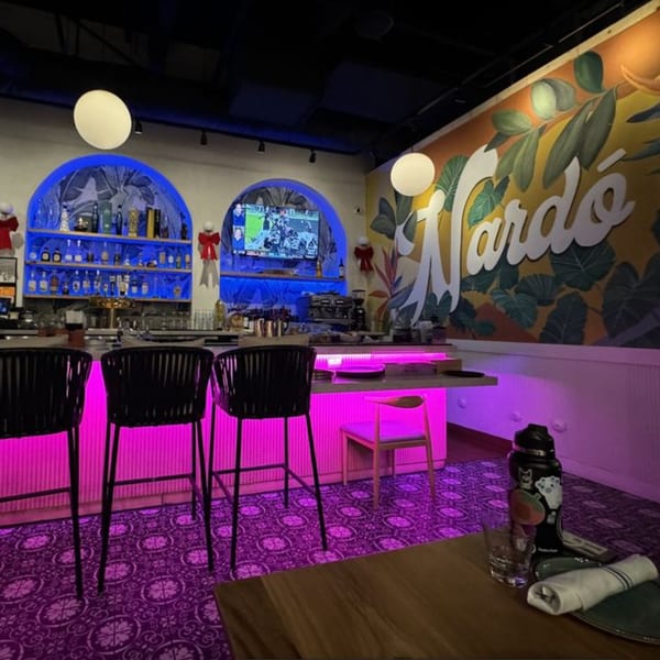 Nardò Italian Restaurant bar area with purple lighting, arched shelves, and a large Nardò mural.
