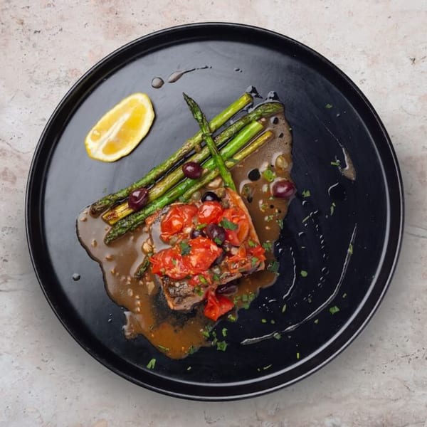 Nardò Italian Restaurant's salmon with cherry tomatoes, olives, asparagus, and a lemon wedge.
