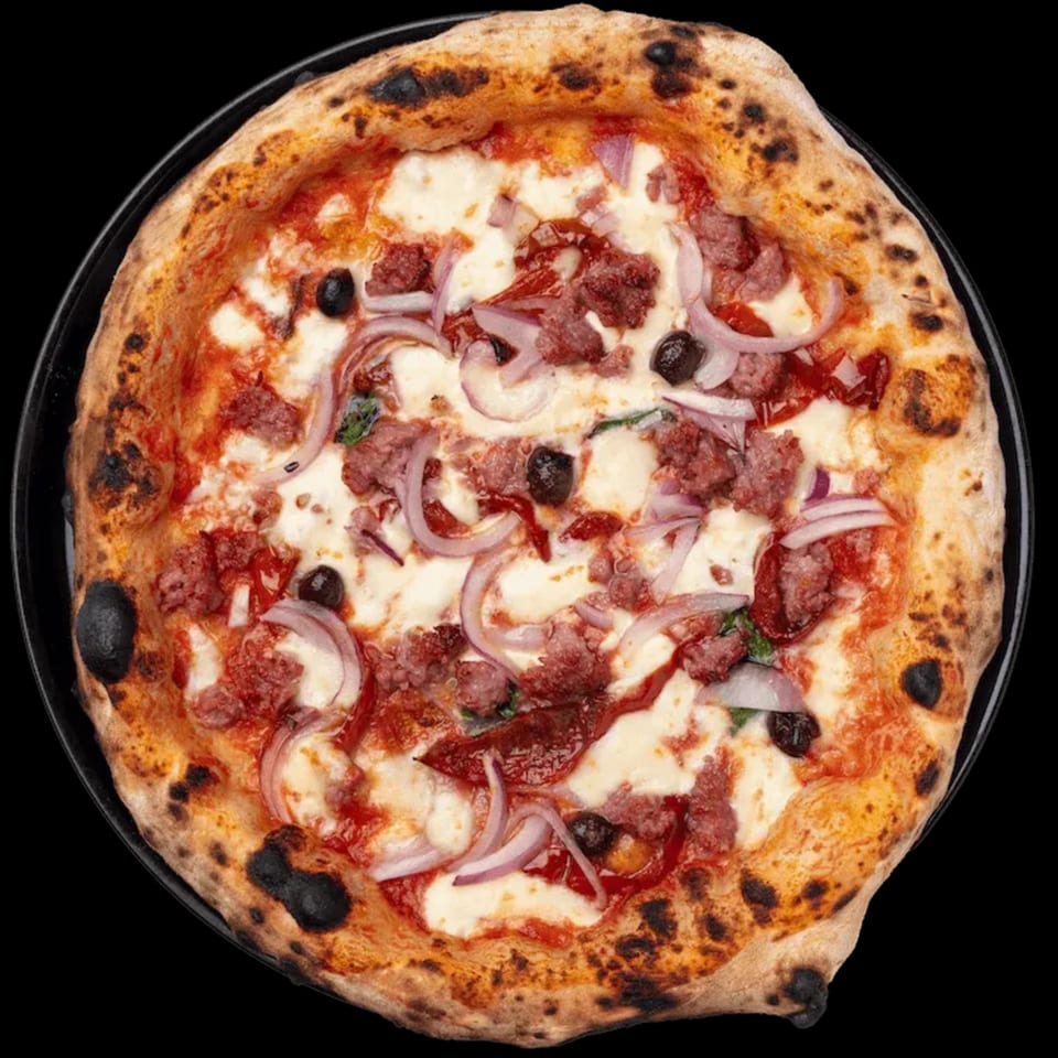 Nardò Italian Restaurant's pizza with sausage, red onion, and black olives on a dark background.