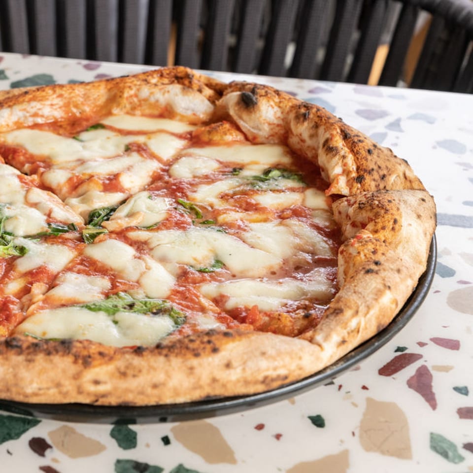Nardò Italian Restaurant's Margherita pizza with a thick, bubbly crust, fresh mozzarella, and basil.