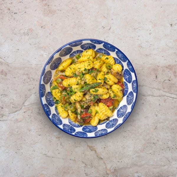 Nardò Italian Restaurant's gnocchi with vegetables and sauce in a blue and white patterned bowl.