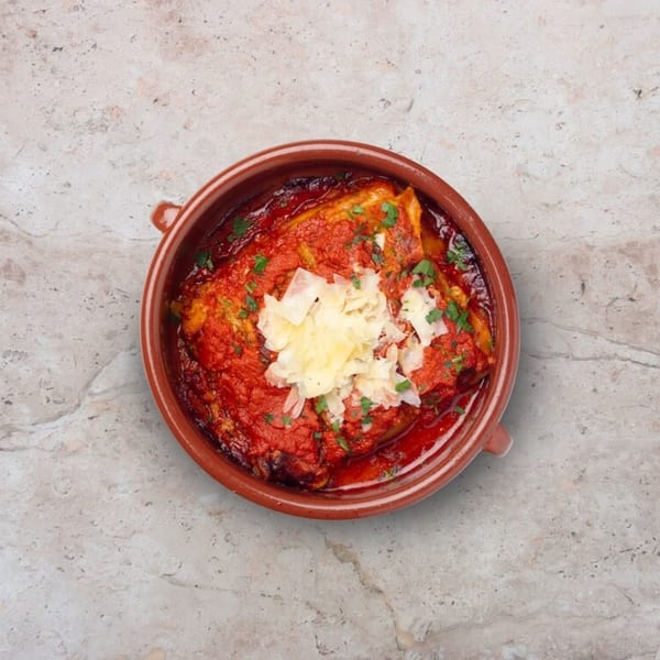 Nardò Italian Restaurant's baked pasta dish with rich red sauce, topped with shaved cheese and parsley.